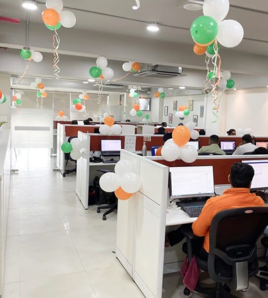 Open-plan desks in the Aakash office, decorated with orange, white and green balloons.